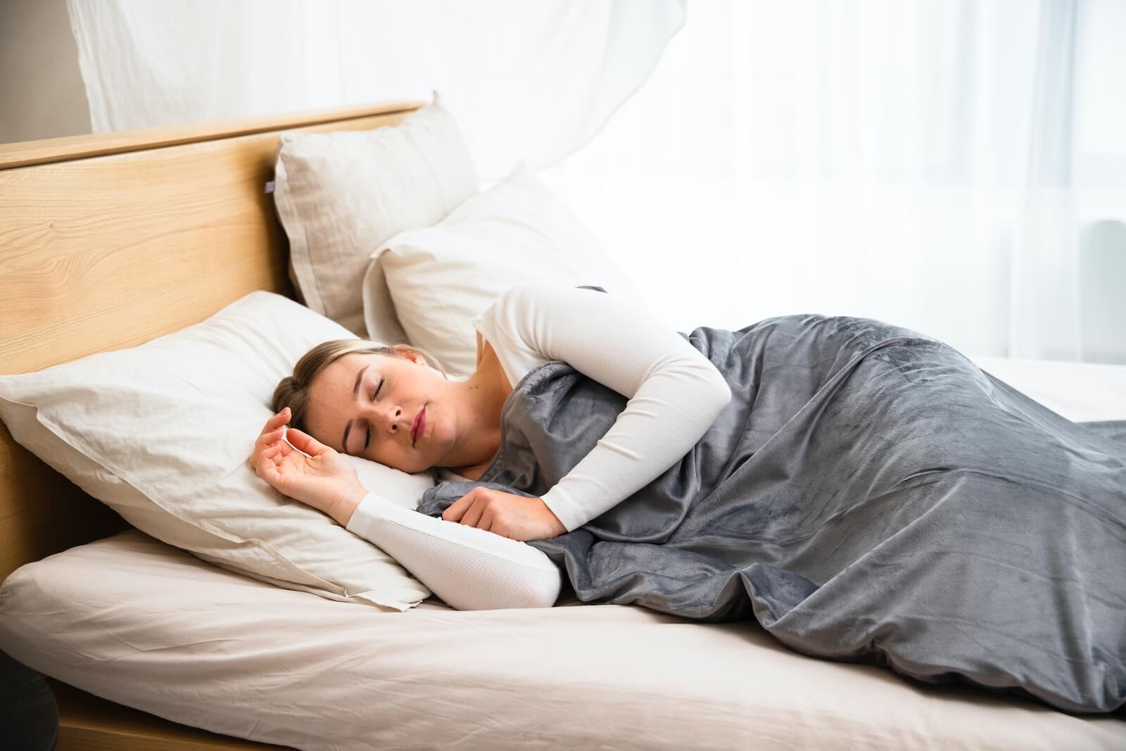 a woman sleeping on a bed with a pillow
