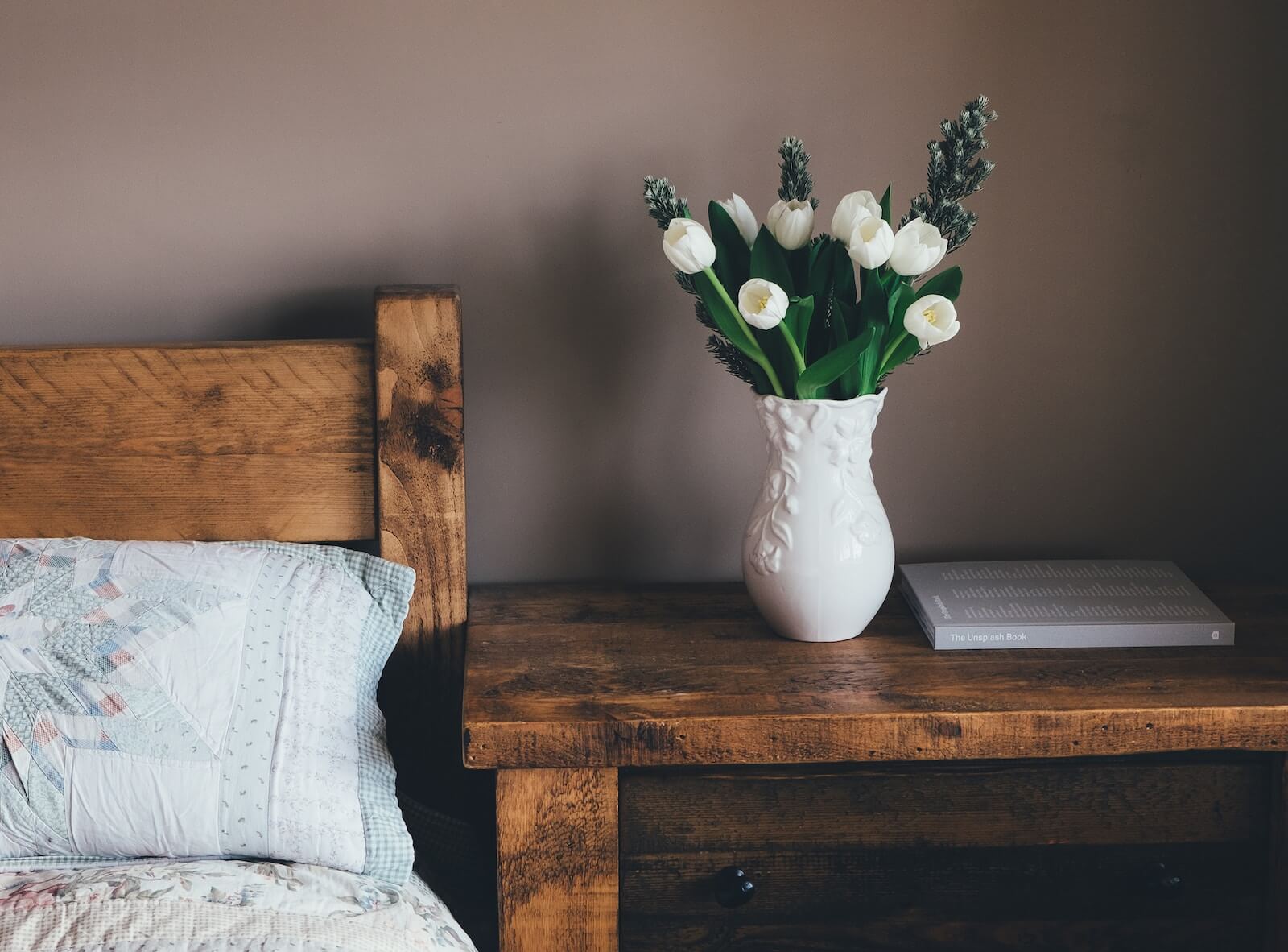 white flower vase on brown bedside table